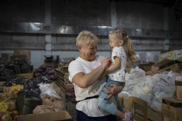 Tatiana, a volunteer and refugee, and her garndaughter in a food warehouse in Moldova.