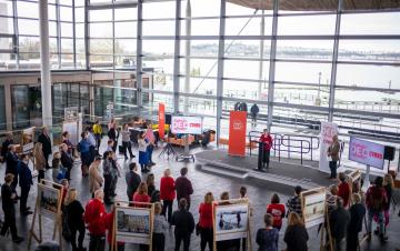 Top view of a gathering with DEC banners and photo exhibition at which DEC representatives thank the Welsh Rapid Response Network and Welsh government.