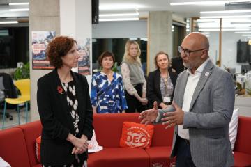 Anneliese Dodds, Minister for Development at the FCDO (at the time), speaks with DEC CEO Saleh Saeed at the DEC office on 29 October 2024. They are standing in discussion with DEC staff in the background.