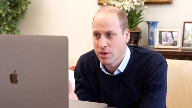 Prince William sits in front of a laptop