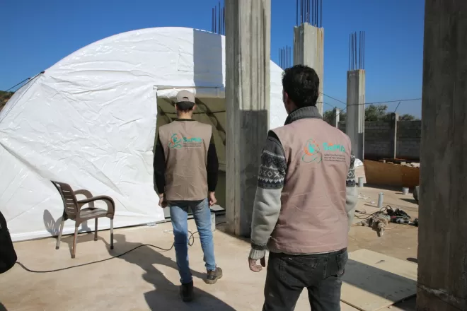 A local partner of Age Internation puts up a tent in north-west Syria