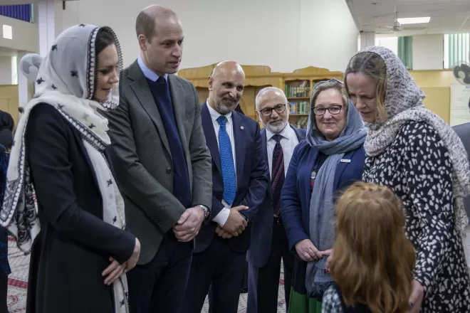 The Prince and Princess of Wales speak to a child at muslim centre