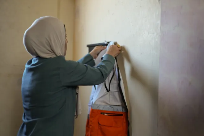Dr Niveen, pictured hanging up her aid worker vest, is a mental health practitioner for the Palestine Red Crescent Society (PRCS) in Gaza, a local partner of DEC charity British Red Cross.