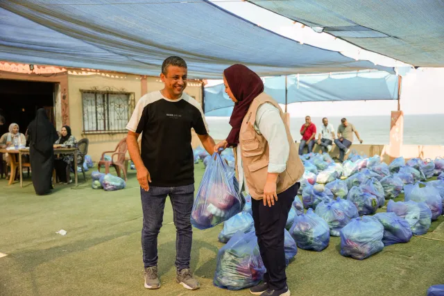 A man collects a bag of fruits and vegetables at a distribution run by a local partner of Action Aid