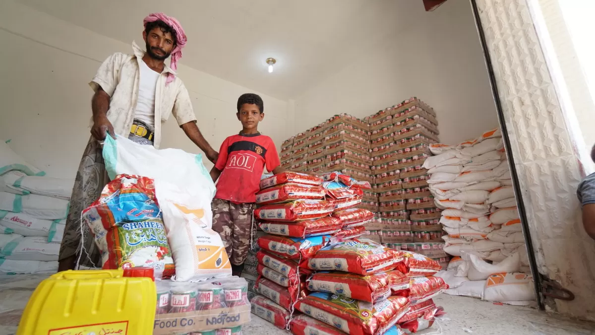 Omar and his son stand by their food basket