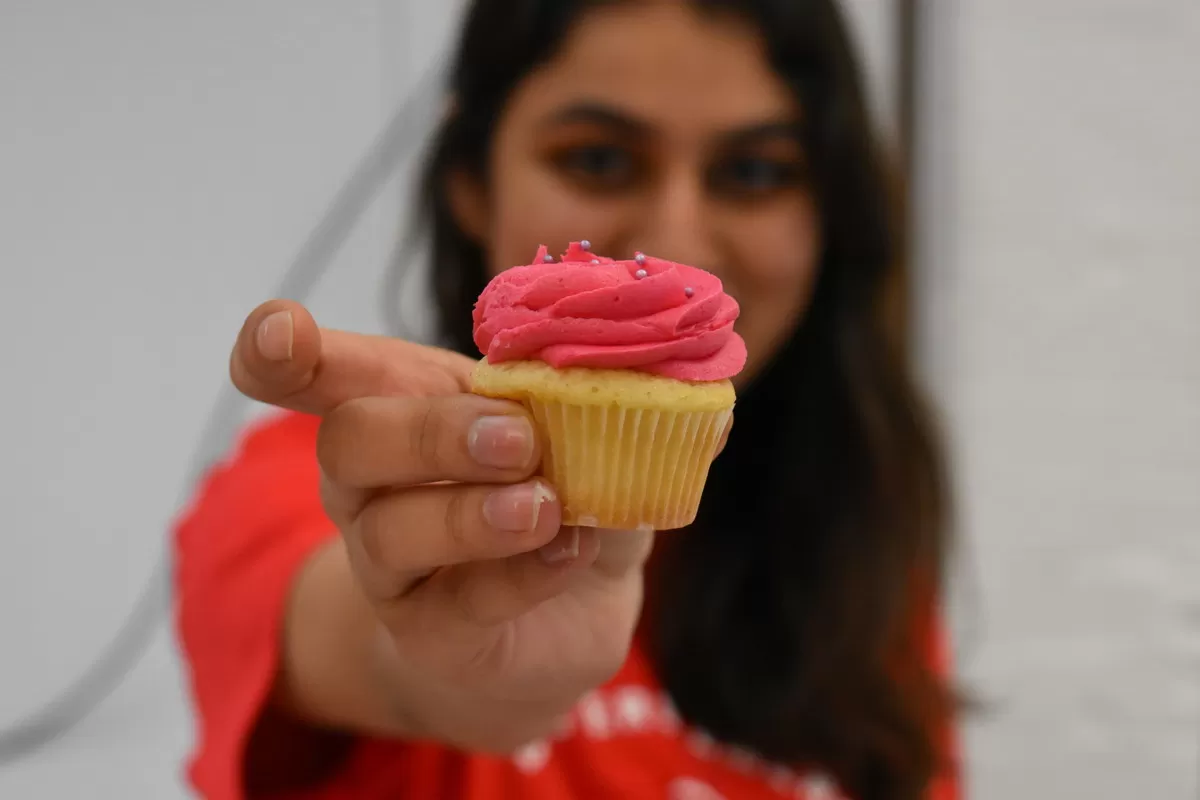 A woman holds up a cake at a DEC fundraiser