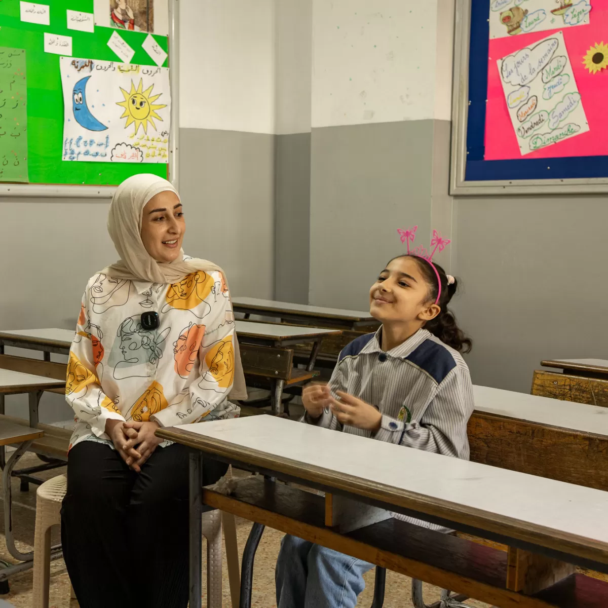 Maryam, a 37-year-old mother sits with her daughter in a classroom in Lebanon