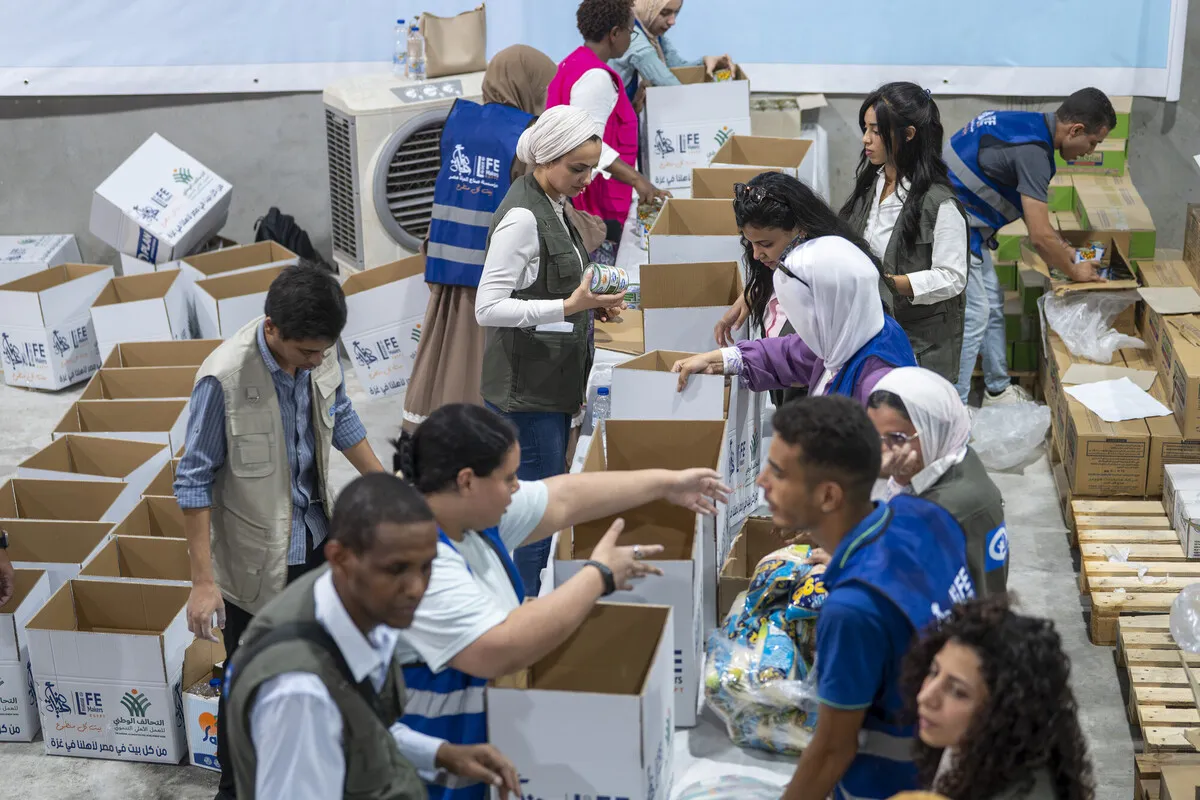 In a warehouse in northern Cairo, volunteers and Plan International staff are packing food parcels for distribution to Gaza