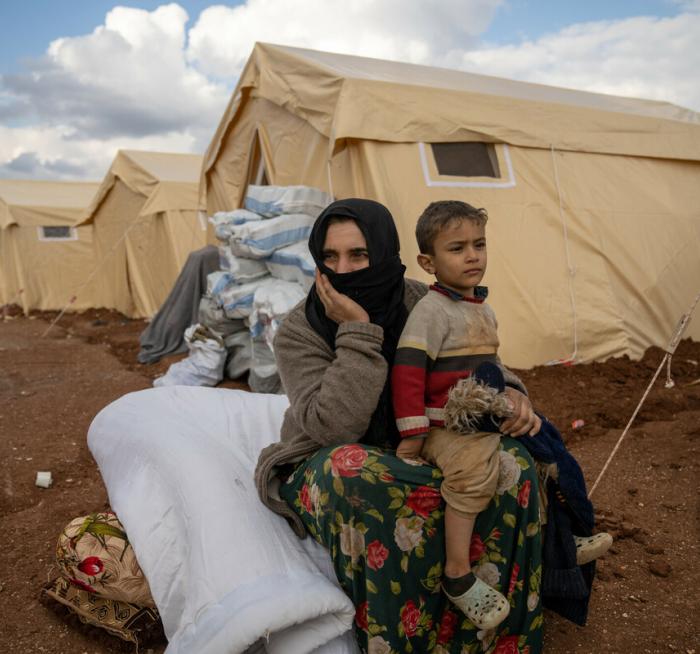 Amal * sits with her son in front of a tent in Jenderes, Syria on the 10th of February 2023