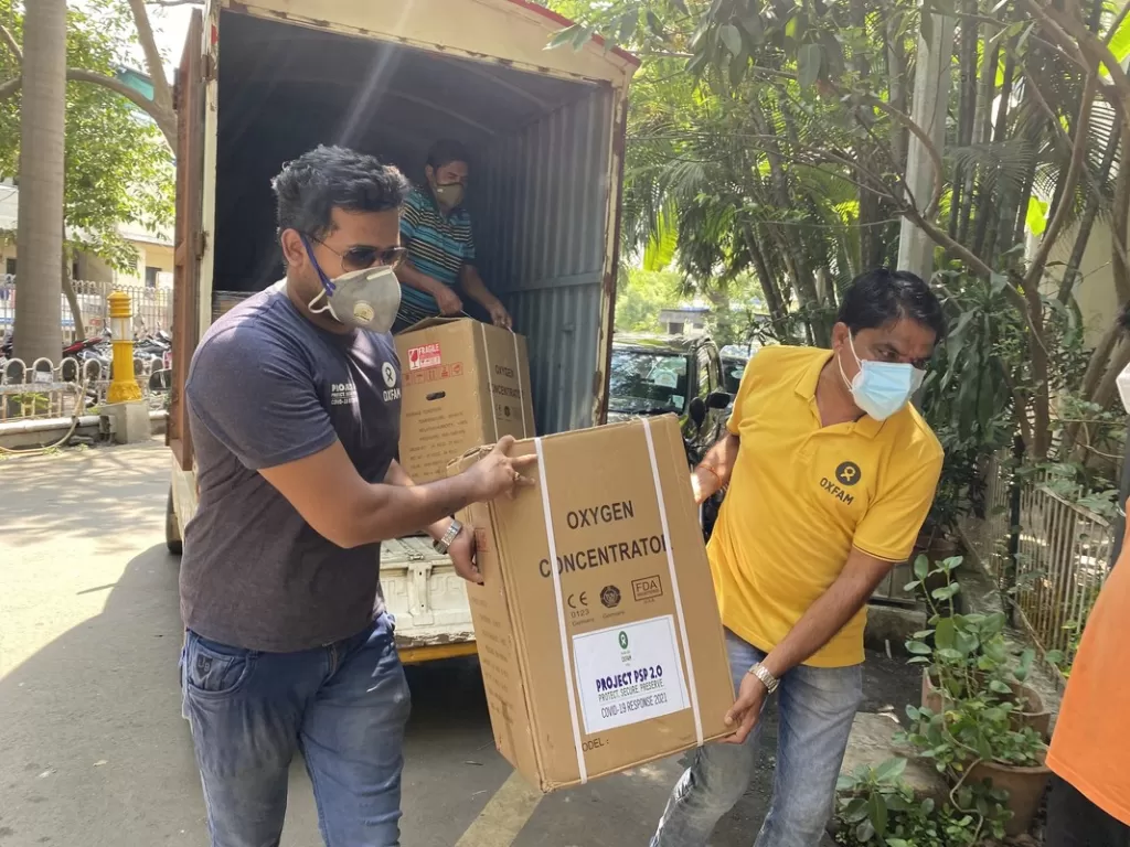 Oxfam staff unload an oxygen concentrator